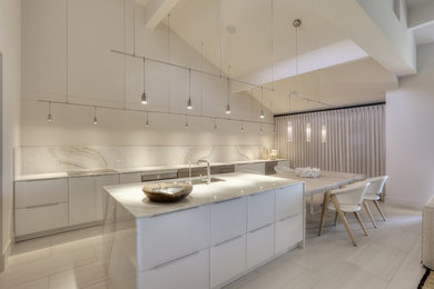 Example of a huge trendy l-shaped ceramic tile and white floor eat-in kitchen design in Jacksonville with an undermount sink, flat-panel cabinets, white cabinets, marble countertops, white backsplash, marble backsplash, stainless steel appliances and an island