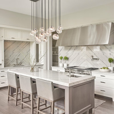 Inspiration for a transitional l-shaped dark wood floor and gray floor kitchen remodel in Chicago with a single-bowl sink, white cabinets, quartzite countertops, stainless steel appliances, shaker cabinets, white backsplash, an island, stone slab backsplash and gray countertops