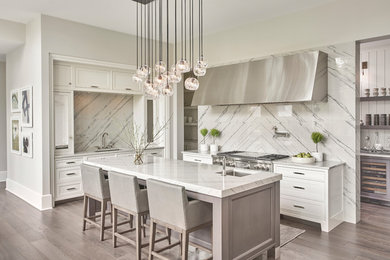 Inspiration for a transitional l-shaped dark wood floor and gray floor kitchen remodel in Chicago with a single-bowl sink, white cabinets, quartzite countertops, stainless steel appliances, shaker cabinets, white backsplash, an island, stone slab backsplash and gray countertops