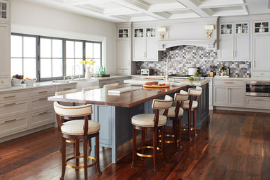 Transitional l-shaped dark wood floor kitchen photo in New York with a farmhouse sink, shaker cabinets, gray cabinets, gray backsplash, stainless steel appliances and an island