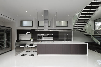 Inspiration for a contemporary kitchen in Houston with flat-panel cabinets, black cabinets, white splashback, stone slab splashback and stainless steel appliances.