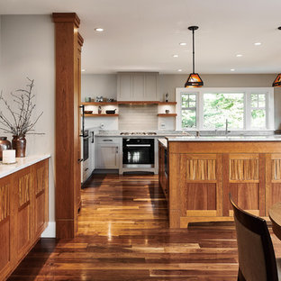 This is an example of a large transitional u-shaped eat-in kitchen in Vancouver with shaker cabinets, medium wood cabinets, quartzite benchtops, multi-coloured splashback, slate splashback, stainless steel appliances, medium hardwood floors, with island and multi-coloured floor.