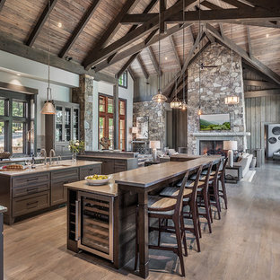Rustic open concept kitchen designs - Example of a mountain style light wood floor open concept kitchen design in Other with an undermount sink, glass-front cabinets, brown cabinets, window backsplash, stainless steel appliances, two islands and gray countertops
