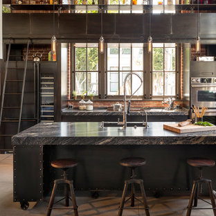 Inspiration for a mid-sized industrial galley eat-in kitchen in San Francisco with with island, flat-panel cabinets, stainless steel cabinets, marble benchtops, stainless steel appliances, concrete floors and an undermount sink.