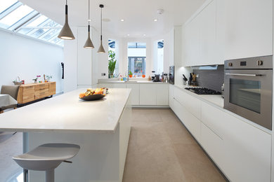 This is an example of a large contemporary l-shaped kitchen/diner in London with a built-in sink, flat-panel cabinets, white cabinets, marble worktops, grey splashback, terracotta splashback, stainless steel appliances, porcelain flooring, an island, grey floors and white worktops.