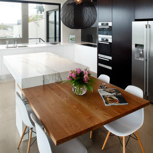 Photo of a medium sized contemporary l-shaped enclosed kitchen in Sydney with flat-panel cabinets, black cabinets, marble worktops, glass sheet splashback, stainless steel appliances, porcelain flooring and an island.