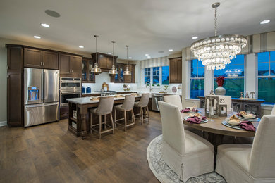 Example of a trendy l-shaped kitchen design in Philadelphia with dark wood cabinets, quartz countertops, ceramic backsplash, stainless steel appliances and an island