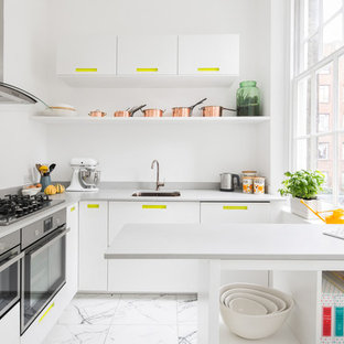 Photo of a small contemporary u-shaped enclosed kitchen in London with flat-panel cabinets, white cabinets, stainless steel appliances, white floors, ceramic flooring, a submerged sink and a breakfast bar.