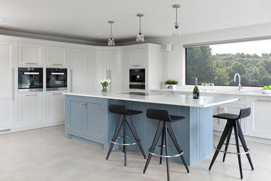 Design ideas for a large contemporary l-shaped open plan kitchen in Belfast with shaker cabinets, grey cabinets, quartz worktops, an island and white worktops.
