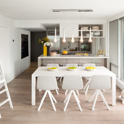 Eat-in kitchen - small scandinavian galley light wood floor eat-in kitchen idea in Vancouver with stainless steel appliances, an undermount sink, flat-panel cabinets, gray cabinets, quartzite countertops, white backsplash, stone slab backsplash and a peninsula
