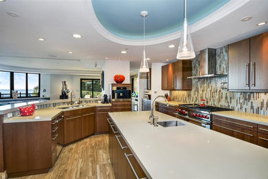 Example of a trendy beige floor open concept kitchen design in San Diego with a double-bowl sink, flat-panel cabinets, dark wood cabinets, multicolored backsplash, matchstick tile backsplash, stainless steel appliances, an island and gray countertops