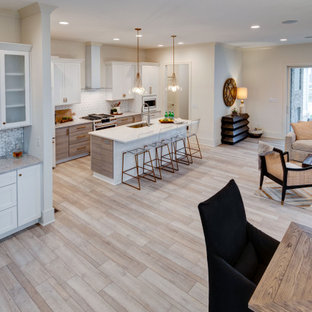 Photo of a mid-sized contemporary single-wall kitchen pantry in Indianapolis with an undermount sink, shaker cabinets, white cabinets, granite benchtops, white splashback, ceramic splashback, white appliances, vinyl floors, with island, multi-coloured floor and white benchtop.