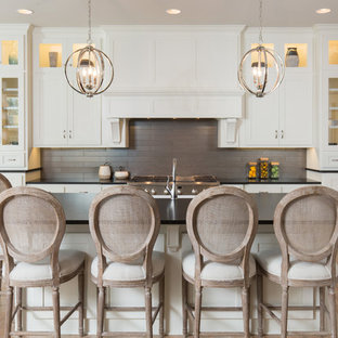 Ispirazione per una cucina stile marinaro con ante in stile shaker, ante bianche, paraspruzzi grigio, elettrodomestici in acciaio inossidabile, parquet chiaro, pavimento beige e top nero