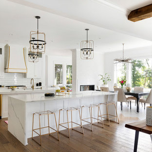 Foto di una grande cucina stile marino con ante bianche, top in quarzite, paraspruzzi bianco, paraspruzzi con piastrelle diamantate, pavimento in legno massello medio, 2 o più isole, top bianco, ante in stile shaker e pavimento marrone