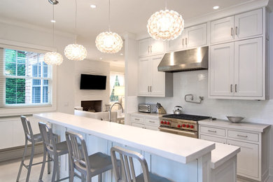 Example of a kitchen design in Other with recessed-panel cabinets, white cabinets, marble countertops, white backsplash, stainless steel appliances and an island