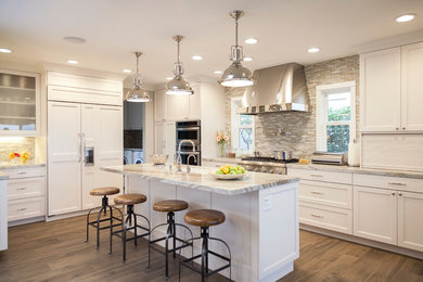 Example of a large transitional medium tone wood floor kitchen design in Los Angeles with an undermount sink, recessed-panel cabinets, white cabinets, quartzite countertops, beige backsplash, matchstick tile backsplash, paneled appliances and an island