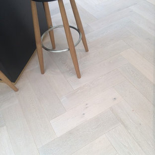 Immagine di una piccola cucina stile marinaro con ante lisce, parquet chiaro, isola e ante blu