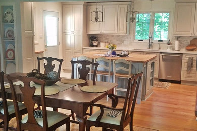 Example of a farmhouse light wood floor eat-in kitchen design in Indianapolis with an undermount sink, white cabinets, marble countertops, multicolored backsplash, subway tile backsplash, stainless steel appliances, an island and white countertops