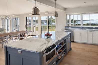 Imagen de cocina tradicional renovada de tamaño medio con fregadero bajoencimera, armarios estilo shaker, puertas de armario blancas, encimera de cuarcita, salpicadero azul, salpicadero de azulejos de vidrio, electrodomésticos de acero inoxidable y una isla