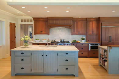 Large arts and crafts single-wall light wood floor eat-in kitchen photo in Portland Maine with medium tone wood cabinets, granite countertops, stone slab backsplash, two islands, a single-bowl sink, shaker cabinets, white backsplash and stainless steel appliances