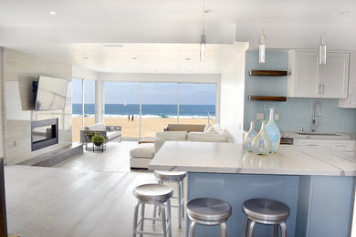 Eat-in kitchen - mid-sized modern u-shaped light wood floor and gray floor eat-in kitchen idea in Los Angeles with a single-bowl sink, shaker cabinets, white cabinets, quartz countertops, blue backsplash, glass tile backsplash, stainless steel appliances and an island