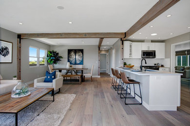 Eat-in kitchen - mid-sized coastal u-shaped medium tone wood floor and beige floor eat-in kitchen idea in San Diego with a single-bowl sink, shaker cabinets, white cabinets, quartz countertops, white backsplash, ceramic backsplash, stainless steel appliances, a peninsula and white countertops