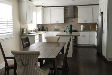 Example of a beach style u-shaped medium tone wood floor eat-in kitchen design in San Diego with an undermount sink, shaker cabinets, white cabinets, quartz countertops, beige backsplash, porcelain backsplash, stainless steel appliances and an island
