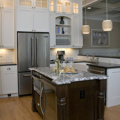 Eat-in kitchen - traditional u-shaped eat-in kitchen idea in Raleigh with stainless steel appliances, a farmhouse sink, granite countertops, shaker cabinets, white cabinets, white backsplash and subway tile backsplash
