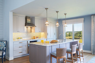Beach style galley medium tone wood floor and brown floor eat-in kitchen photo in Charleston with an undermount sink, shaker cabinets, gray cabinets, ceramic backsplash, blue backsplash, stainless steel appliances and an island