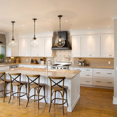 Example of a large transitional l-shaped medium tone wood floor and brown floor eat-in kitchen design in San Luis Obispo with an undermount sink, shaker cabinets, white cabinets, quartzite countertops, beige backsplash, glass tile backsplash, stainless steel appliances and an island