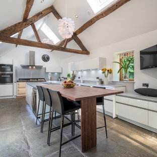 This is an example of a large rustic kitchen in Other with flat-panel cabinets, white cabinets, grey splashback, an island, grey floors and grey worktops.