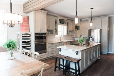 Eat-in kitchen - mid-sized traditional l-shaped dark wood floor and brown floor eat-in kitchen idea in Atlanta with an undermount sink, recessed-panel cabinets, white cabinets, granite countertops, white backsplash, travertine backsplash, stainless steel appliances and an island