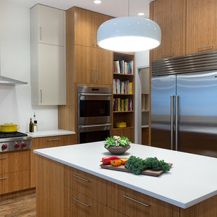 Mid-sized contemporary kitchen designs - Kitchen - mid-sized contemporary medium tone wood floor kitchen idea in New York with flat-panel cabinets, medium tone wood cabinets, quartz countertops, white backsplash, stainless steel appliances and an island