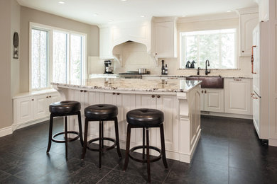 Eat-in kitchen - mid-sized traditional l-shaped porcelain tile and black floor eat-in kitchen idea in Calgary with a farmhouse sink, raised-panel cabinets, white cabinets, granite countertops, beige backsplash, ceramic backsplash, paneled appliances, an island and multicolored countertops
