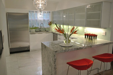 Eat-in kitchen - mid-sized contemporary u-shaped white floor and porcelain tile eat-in kitchen idea in Miami with an undermount sink, flat-panel cabinets, white cabinets, granite countertops, glass sheet backsplash, stainless steel appliances, a peninsula and blue backsplash