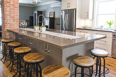 Eat-in kitchen - mid-sized modern galley medium tone wood floor eat-in kitchen idea in Toronto with an undermount sink, flat-panel cabinets, gray cabinets, granite countertops, white backsplash, subway tile backsplash, stainless steel appliances and an island
