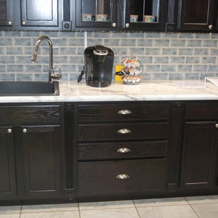 Inspiration for a small transitional single-wall eat-in kitchen in Omaha with a drop-in sink, recessed-panel cabinets, dark wood cabinets, blue splashback, ceramic splashback, black appliances, porcelain floors and no island.
