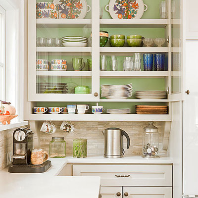 Example of a classic kitchen design in Atlanta with glass-front cabinets, white cabinets, beige backsplash and travertine backsplash