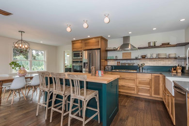 Example of a large farmhouse l-shaped medium tone wood floor and brown floor open concept kitchen design in New York with a farmhouse sink, shaker cabinets, medium tone wood cabinets, quartzite countertops, white backsplash, marble backsplash, stainless steel appliances and an island