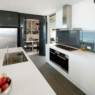 Photo of a contemporary kitchen in Sydney with a drop-in sink, flat-panel cabinets, white cabinets, grey splashback and glass sheet splashback.