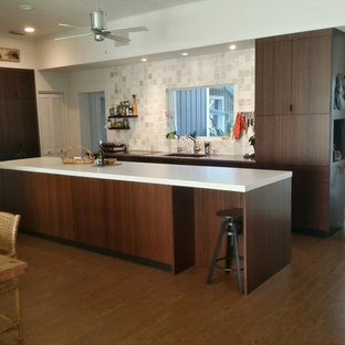 This is an example of a mid-sized modern galley eat-in kitchen in Orlando with an undermount sink, flat-panel cabinets, dark wood cabinets, concrete benchtops, beige splashback, stone tile splashback, black appliances, cork floors, with island and brown floor.