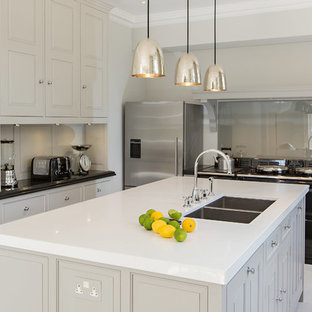 Inspiration for a medium sized classic u-shaped kitchen in Other with a double-bowl sink, recessed-panel cabinets, grey cabinets, glass sheet splashback, stainless steel appliances and an island.