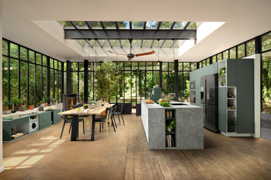 Photo of a large modern single-wall kitchen/diner in Surrey with a single-bowl sink, flat-panel cabinets, green cabinets, laminate countertops, black appliances, an island and grey worktops.