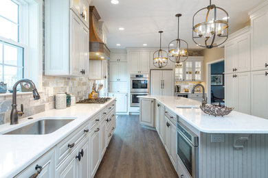 Elegant kitchen photo in Philadelphia with raised-panel cabinets, quartz countertops and an island