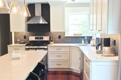 フィラデルフィアにある高級な中くらいなトランジショナルスタイルのおしゃれなキッチン (グレーのキッチンパネル、大理石のキッチンパネル、シルバーの調理設備、茶色い床、白いキッチンカウンター) の写真