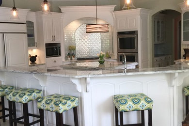 Inspiration for a large timeless u-shaped ceramic tile and brown floor open concept kitchen remodel in Dallas with a farmhouse sink, raised-panel cabinets, white cabinets, granite countertops, stainless steel appliances, two islands, white backsplash and subway tile backsplash