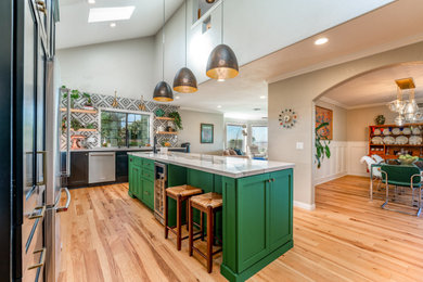 Mid-sized eclectic l-shaped medium tone wood floor and vaulted ceiling eat-in kitchen photo in Los Angeles with a single-bowl sink, shaker cabinets, quartz countertops, porcelain backsplash, stainless steel appliances and an island