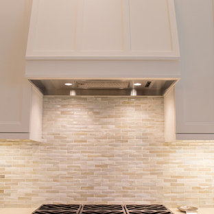 Large beach style l-shaped open plan kitchen in Miami with an undermount sink, recessed-panel cabinets, white cabinets, quartz benchtops, beige splashback, matchstick tile splashback, stainless steel appliances, ceramic floors, with island and beige floor.