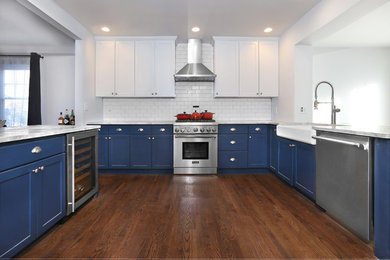 Inspiration for a mid-sized timeless u-shaped laminate floor eat-in kitchen remodel in Other with a farmhouse sink, white cabinets, quartz countertops, white backsplash, subway tile backsplash, stainless steel appliances, a peninsula and recessed-panel cabinets