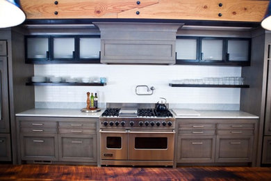 Idéer för ett avskilt, mellanstort modernt linjärt kök, med luckor med infälld panel, grå skåp, bänkskiva i kvartsit, vitt stänkskydd, stänkskydd i tunnelbanekakel, rostfria vitvaror och mellanmörkt trägolv